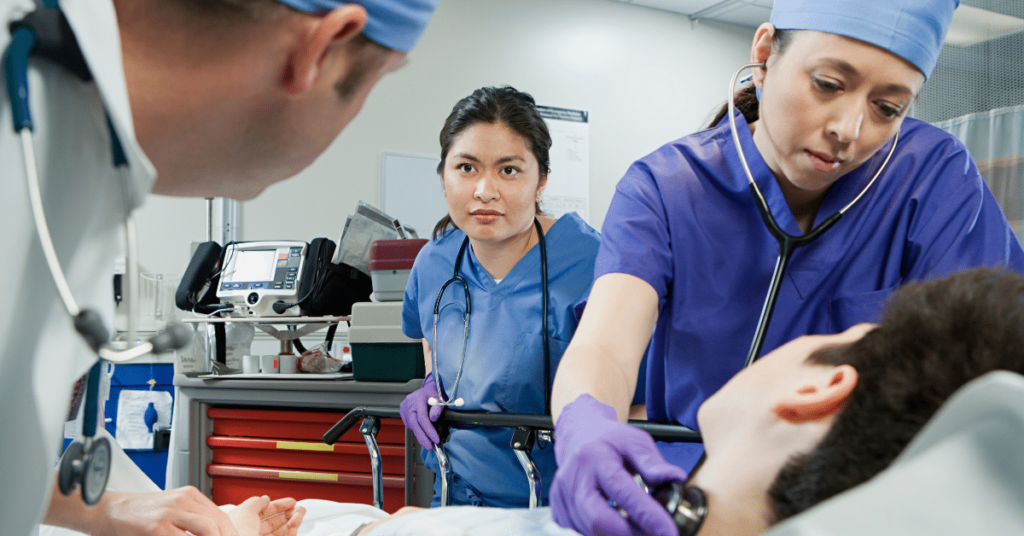 Medical professionals, including nurses and a doctor, attentively care for a patient in an emergency room. They are part of a team of Travel Nurses contributing to disaster relief efforts.
