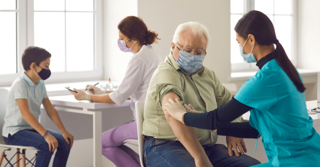 Nurses administering flu shots to an older adult and a child during the fall flu season.