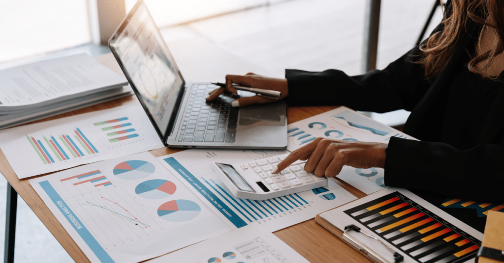 Close-up of a financial adviser's hands meticulously working on a report related to the stabilization of travel nurse salaries in 2023 and its implications.